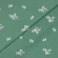 Izšūts, mazgāts kokvilnas audums- balti ziedi uz zaļpelēka fona 120 g/m²